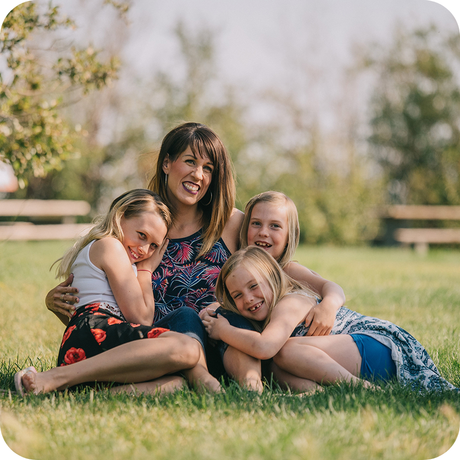 Woman And Children Sitting On Grass